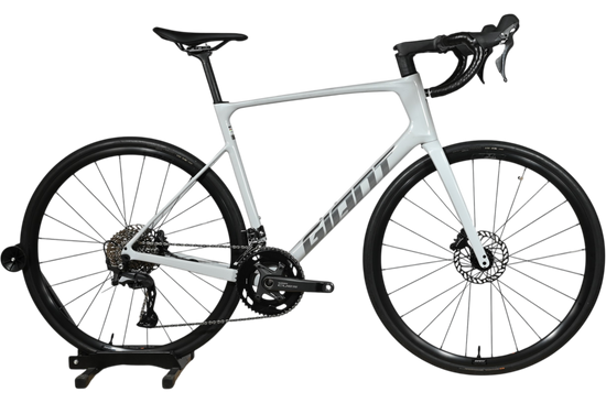 Vélo de route Giant Defy Advanced 3 2026 gris clair chez Loop Sports sur un support en bois
