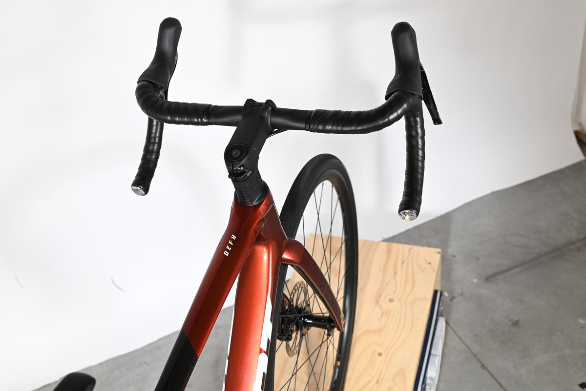 Vue plongeante sur le guidon et le cadre rouge brillant du vélo de route Giant Defy Advanced 2 chez Loop Sports