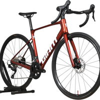 Vélo de route Giant Defy Advanced 2 2025 rouge métallique chez Loop Sports sur support en bois