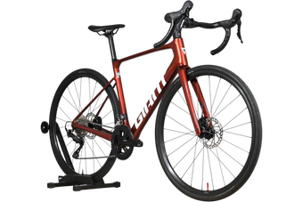 Vélo de route Giant Defy Advanced 2 2025 rouge métallique chez Loop Sports sur support en bois
