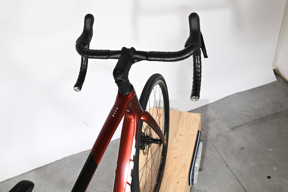 Vue plongeante sur le guidon et le cadre rouge brillant du vélo de route Giant Defy Advanced 2 chez Loop Sports