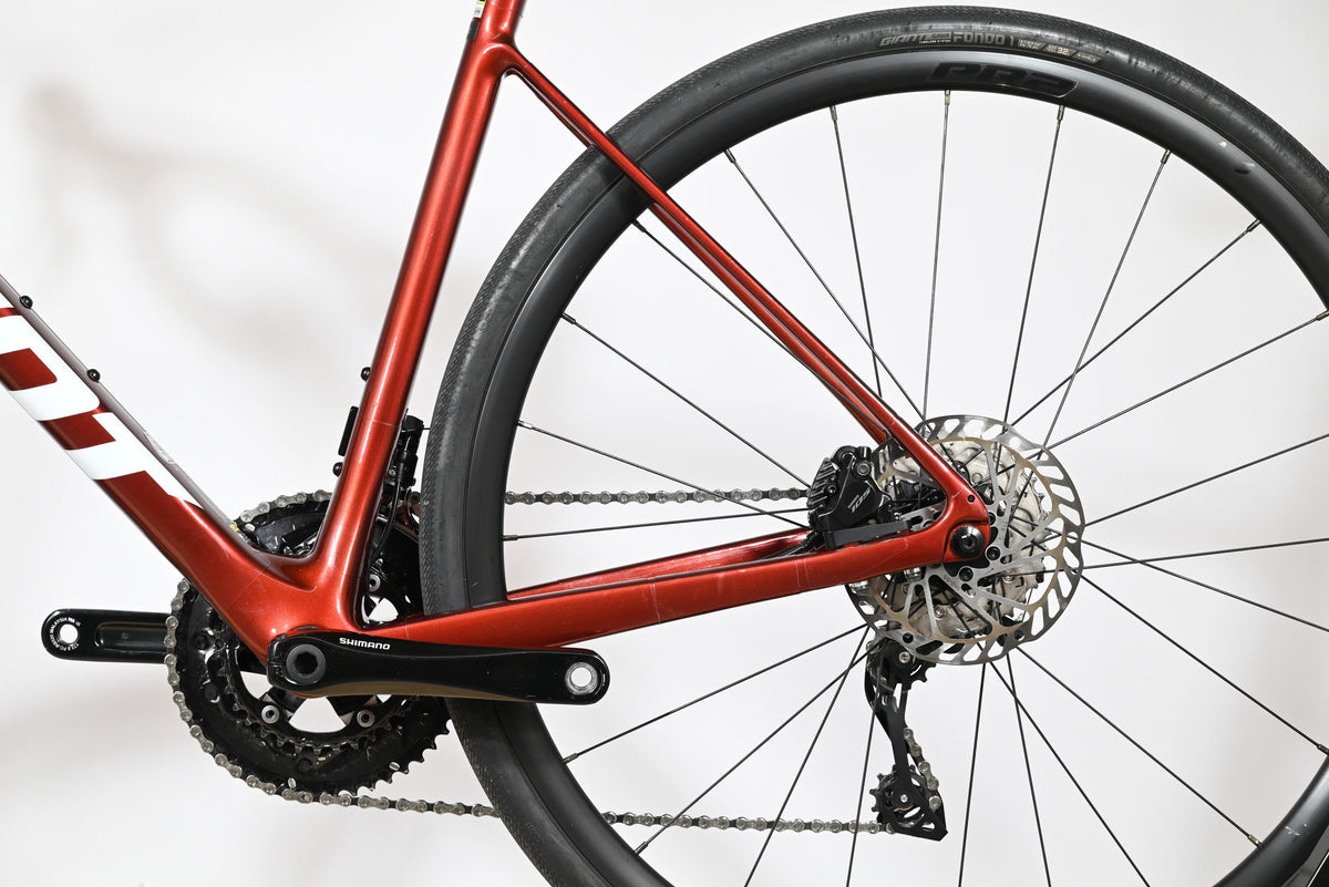 Gros plan sur la roue arrière et le cadre rouge brillant du vélo de route Giant Defy Advanced 2 chez Loop Sports