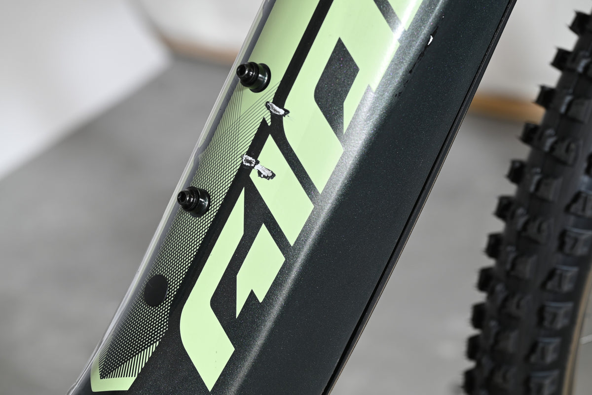 Gros plan sur le cadre noir et vert du vélo électrique Giant Fathom E+1 de Loop Sports avec des éraflures visibles.