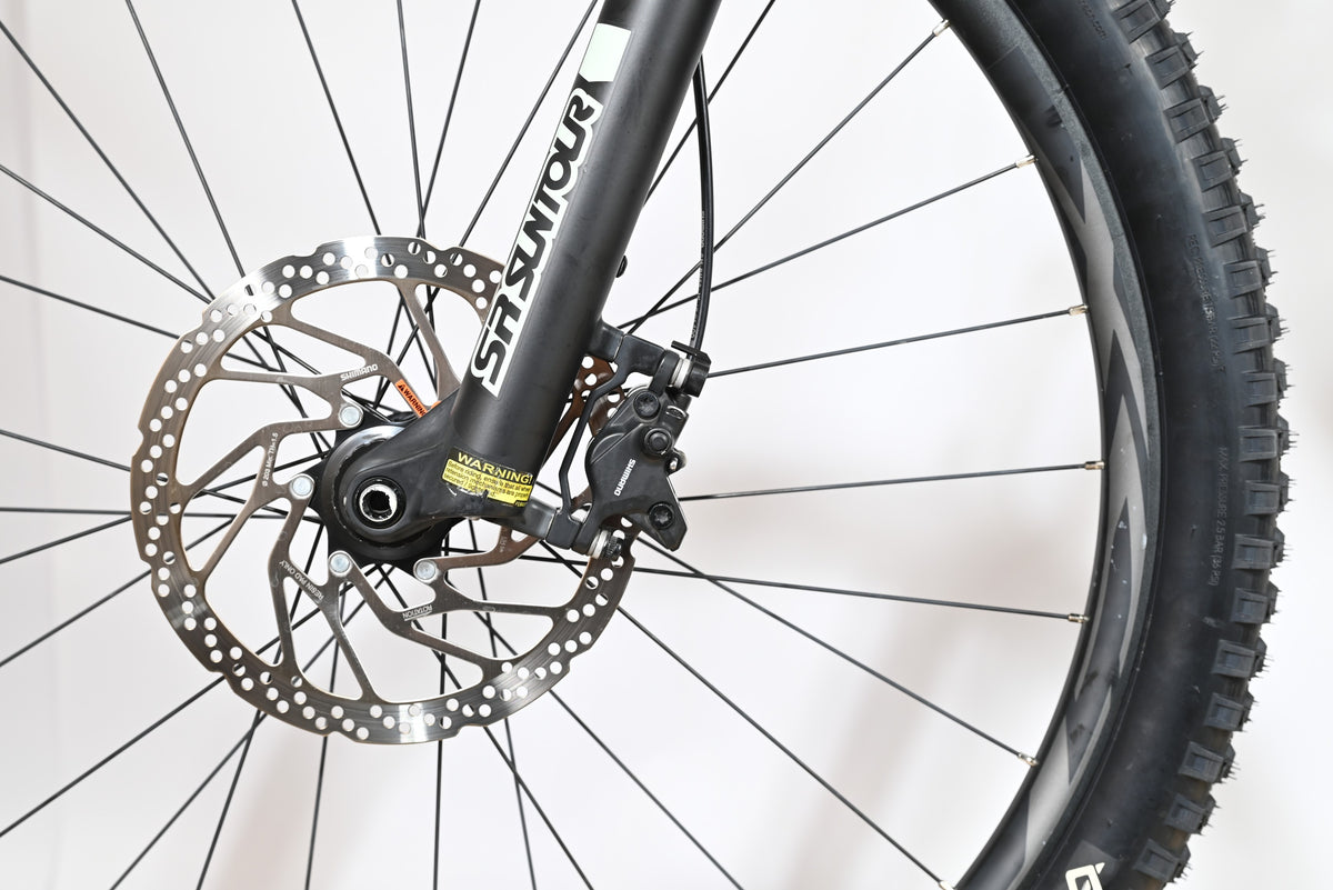 Gros plan sur le frein à disque hydraulique et la fourche SR Suntour du vélo électrique Giant Fathom E+1 Loop Sports