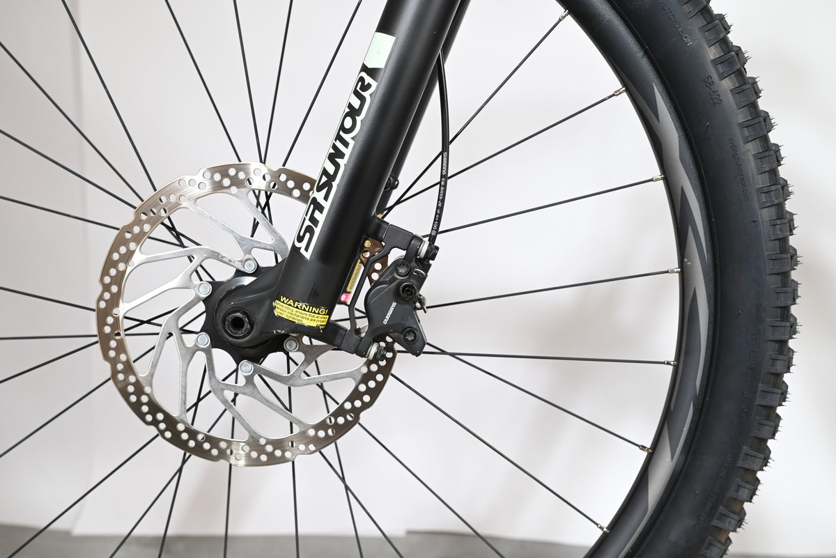 Gros plan sur le frein à disque hydraulique et la fourche SR Suntour du vélo électrique Giant Fathom E+1 Loop Sports