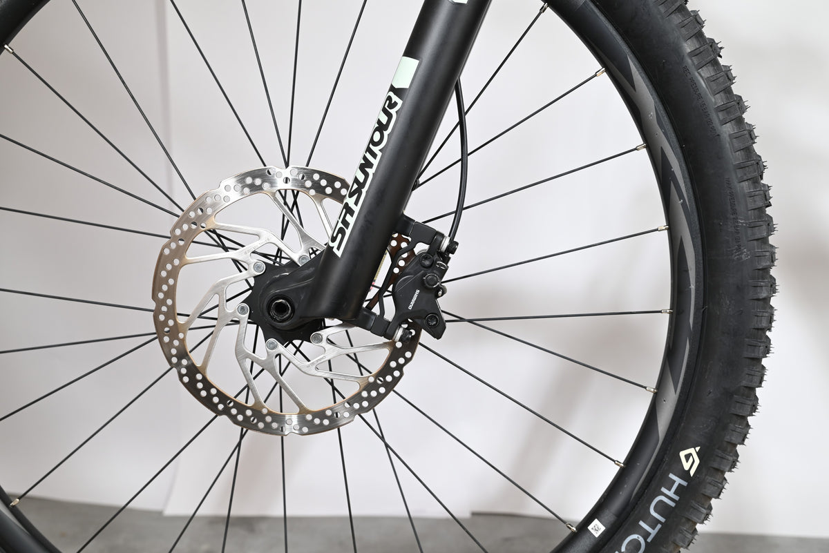 Gros plan sur le frein à disque hydraulique et la fourche SR Suntour du vélo électrique Giant Fathom E+1 Loop Sports