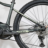 Vue latérale du cadre et de la roue arrière du vélo électrique Giant Fathom E+1 chez Loop Sports, couleur gris foncé.