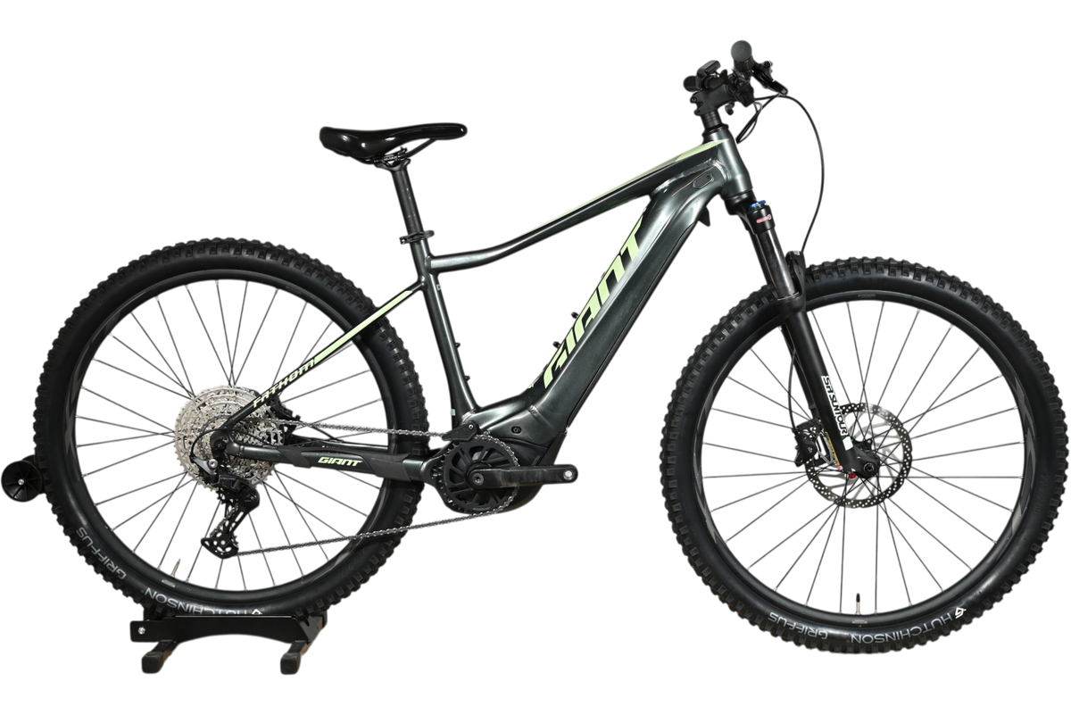Velo electrique tout-terrain Giant Fathom E+1 gris avec accents vert lime, disponible chez Loop Sports