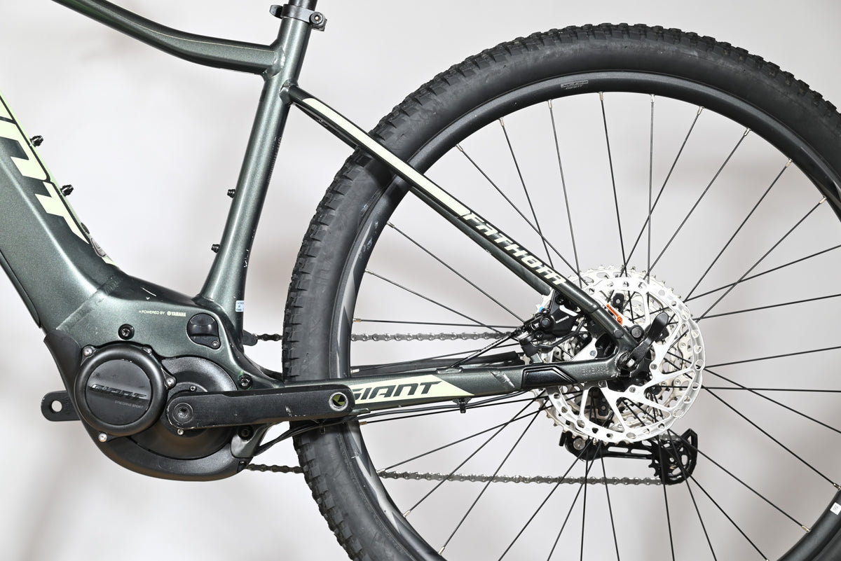 Vue latérale arrière du vélo électrique Giant Fathom E+1 de Loop Sports, cadre gris et détails vert clair