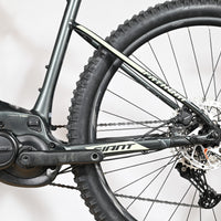 Velo electrique VTT Loop Sports Giant Fathom E+1 gris avec moteur central Yamaha et freins a disque
