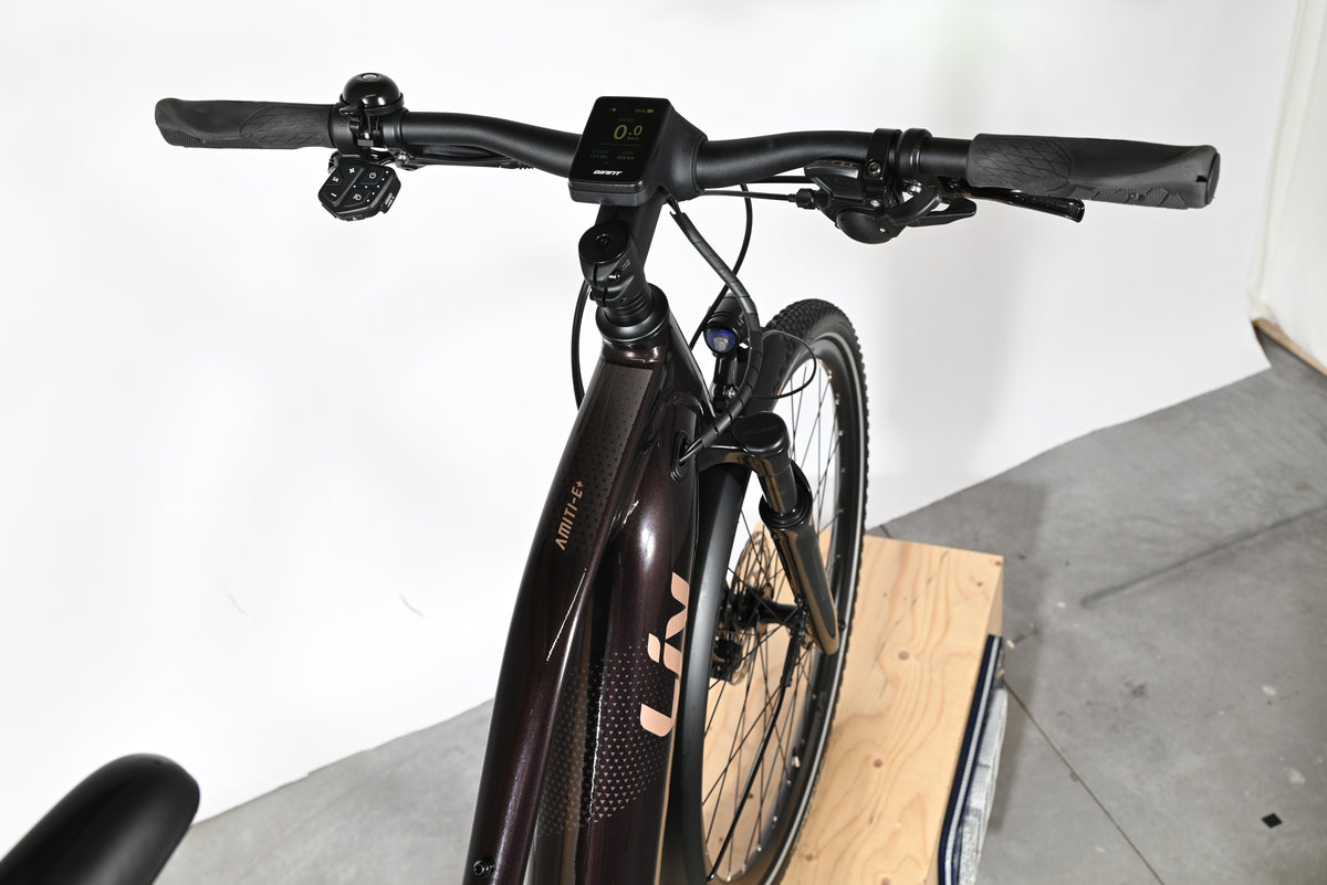 Vue rapprochée du guidon et du cadre du vélo électrique Loop Sports Giant Liv Amiti E+2 de couleur brun foncé