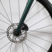 Gros plan sur la fourche vert foncé et le frein à disque hydraulique du vélo de route Loop Sports Giant Liv Avail