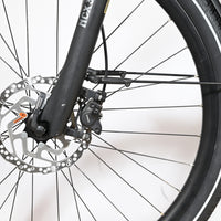 Gros plan sur le frein à disque hydraulique Shimano et la fourche suspendue NCX du vélo électrique Loop Sports KTM Cento