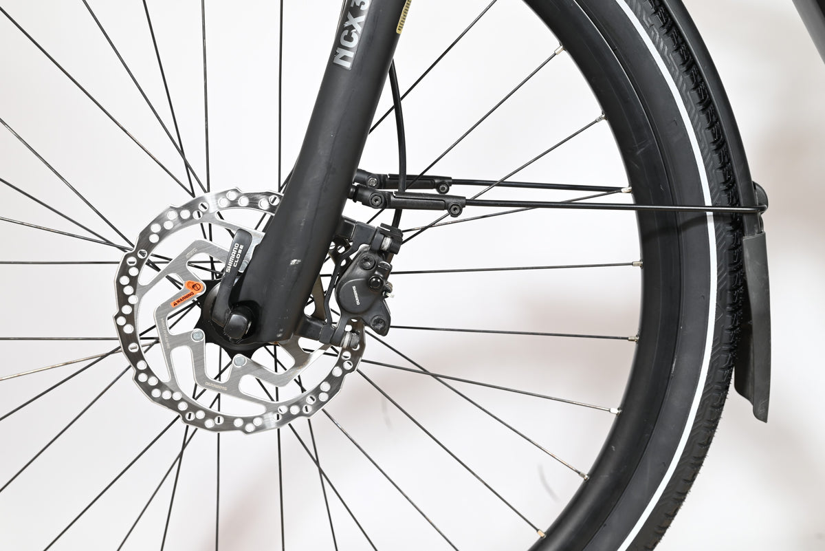 Gros plan sur le frein à disque hydraulique Shimano et la fourche suspendue NCX du vélo électrique Loop Sports KTM Cento