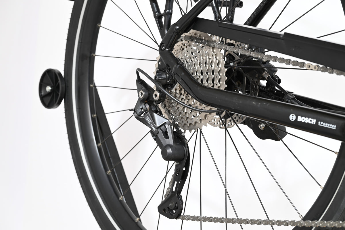 Gros plan sur le dérailleur arrière Shimano Deore et la cassette du vélo électrique Loop Sports KTM Macina Tour
