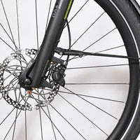 Gros plan sur le frein à disque hydraulique Shimano et la fourche avant du vélo électrique Loop Sports KTM Macina Tour