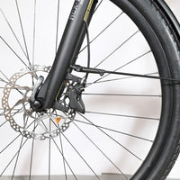 Gros plan sur la roue avant et le frein à disque hydraulique du vélo électrique Loop Sports KTM Macina Style 720