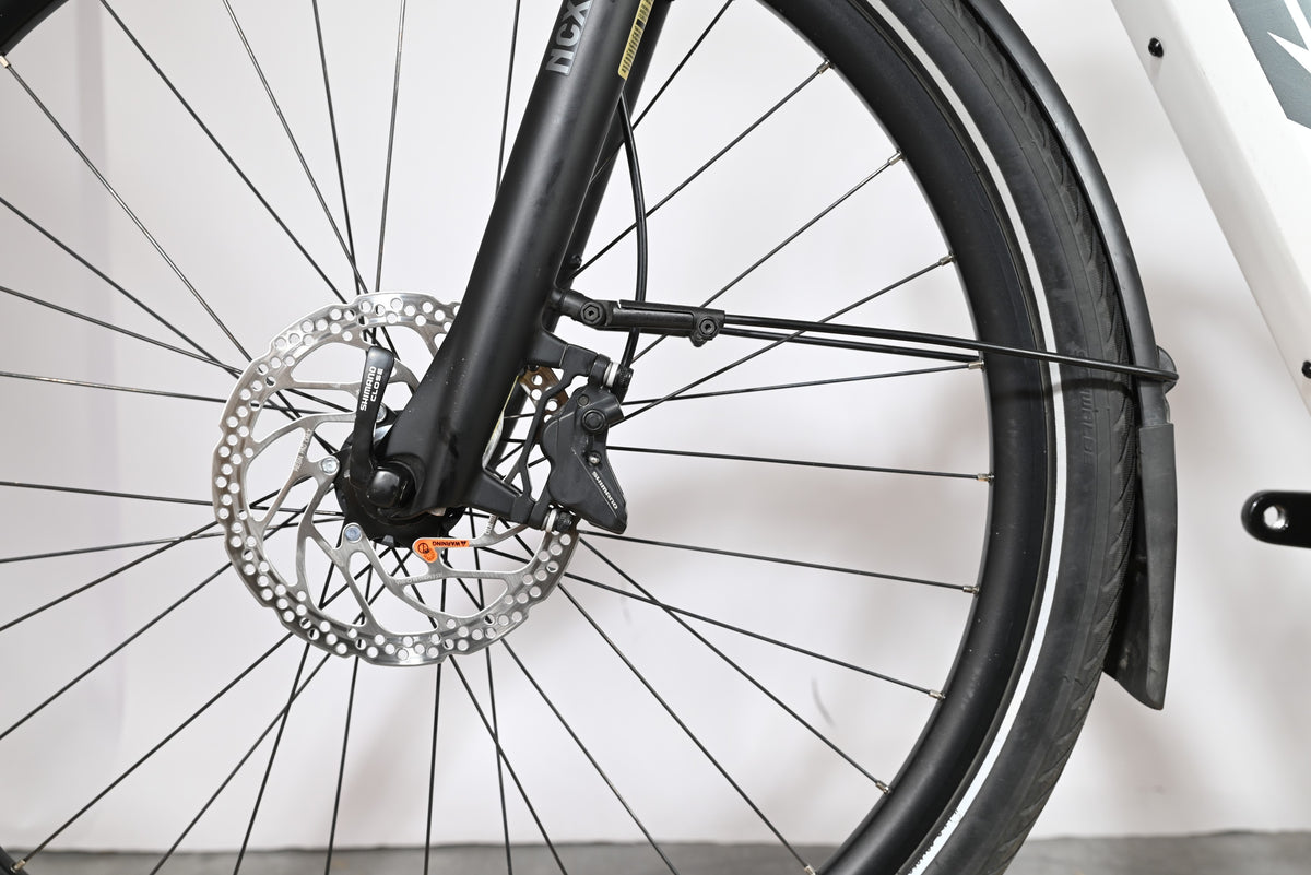 Gros plan sur le frein à disque hydraulique Shimano et la roue avant du vélo électrique Loop Sports KTM Macina Style