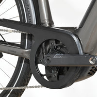 Gros plan sur le pédalier et le moteur Bosch d'un vélo électrique Loop Sports KTM Macina Style XL gris