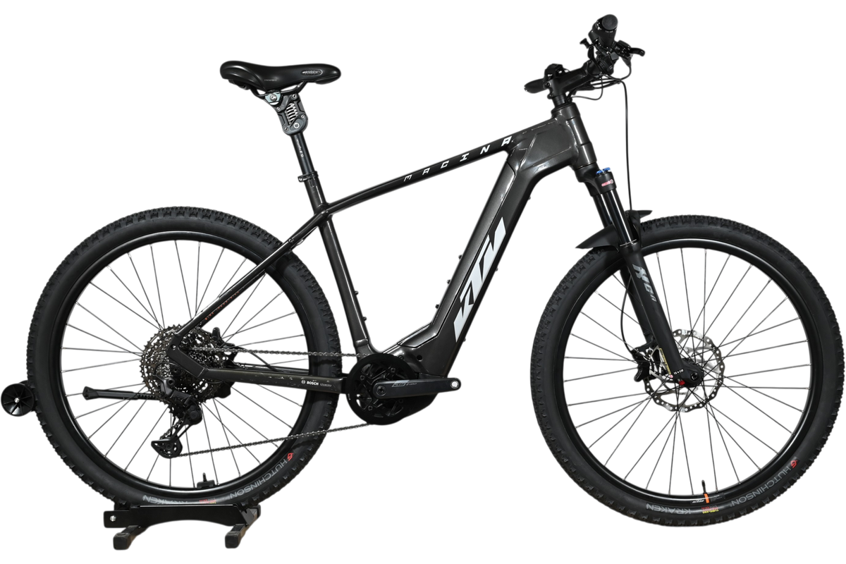 Velo electrique VTT KTM Macina Team noir de Loop Sports sur socle en bois