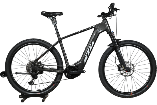 Velo electrique VTT KTM Macina Team noir de Loop Sports sur socle en bois