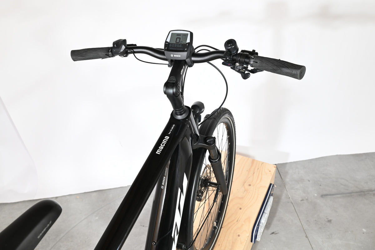 Vue rapprochée du guidon et du cadre noir du vélo électrique Loop Sports KTM Macina Tour CX 625 LTD avec écran Bosch