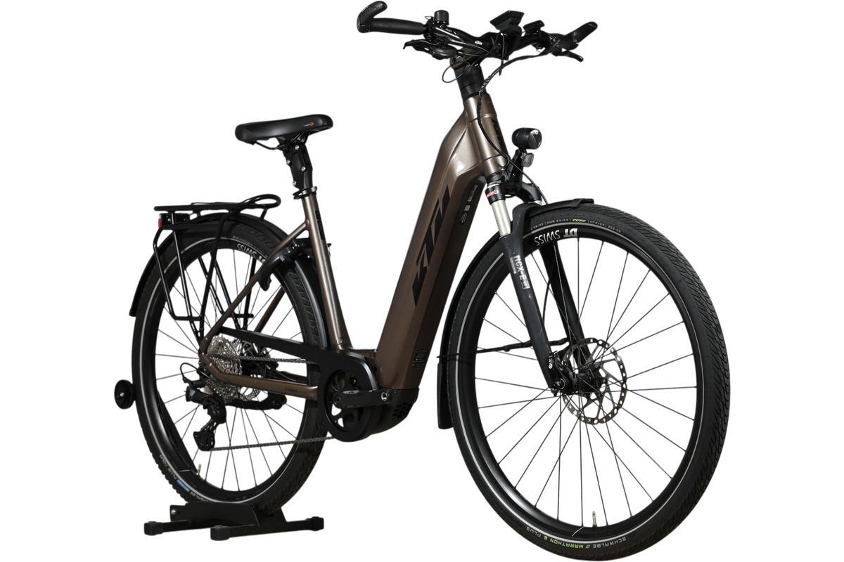 Vélo électrique KTM Macina Style 710 marron de Loop Sports avec cadre ouvert, porte-bagages et pneus tout-terrain