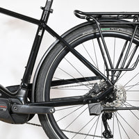 Vue latérale arrière du vélo électrique noir Loop Sports KTM Macina Tour CX 625 avec porte-bagages et moteur Bosch