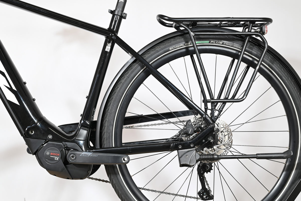 Vue latérale arrière du vélo électrique noir Loop Sports KTM Macina Tour CX 625 avec porte-bagages et moteur Bosch