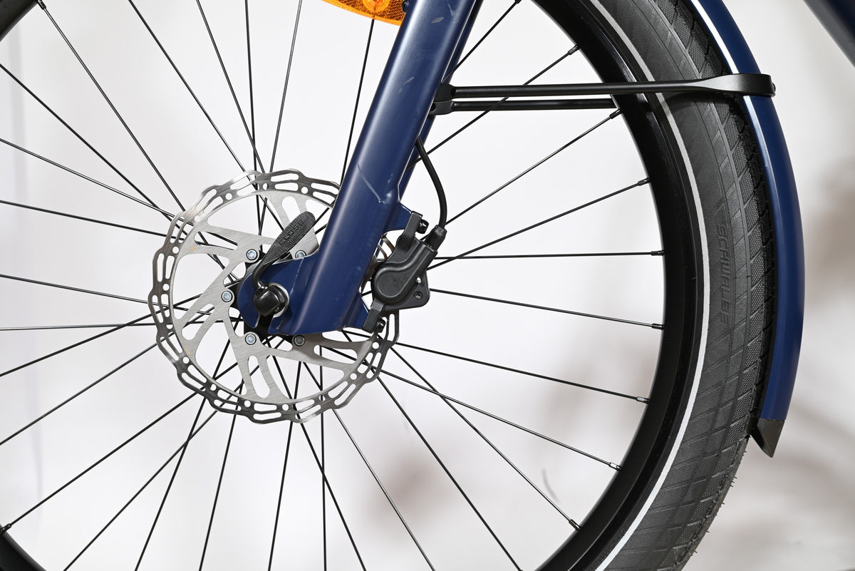 Gros plan sur la roue avant, le frein à disque et la fourche bleue du vélo électrique Loop Sports Moustache Lundi 27.6