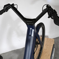 Vue plongeante sur le guidon et le cadre bleu marine du vélo électrique Moustache Lundi 27.6 chez Loop Sports