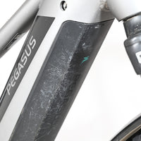 Gros plan sur le cadre gris et la batterie du vélo électrique Pegasus Evo CX 750 de Loop Sports avec traces d'usure