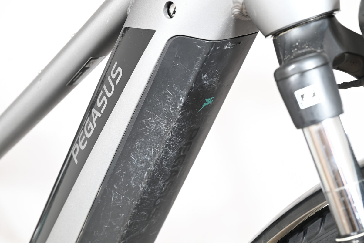 Gros plan sur le cadre gris et la batterie du vélo électrique Pegasus Evo CX 750 de Loop Sports avec traces d'usure