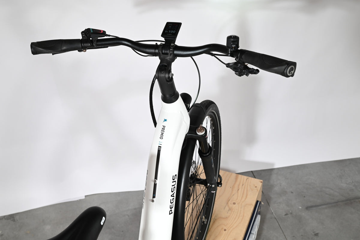 Vue rapprochée du guidon et du cadre blanc du vélo électrique Loop Sports Pegasus Premio Evo 11 40 Years