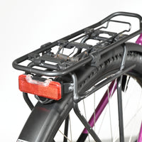 Porte-bagages noir avec feu arrière rouge sur vélo électrique violet Victoria Trekking 11.5 de Loop Sports