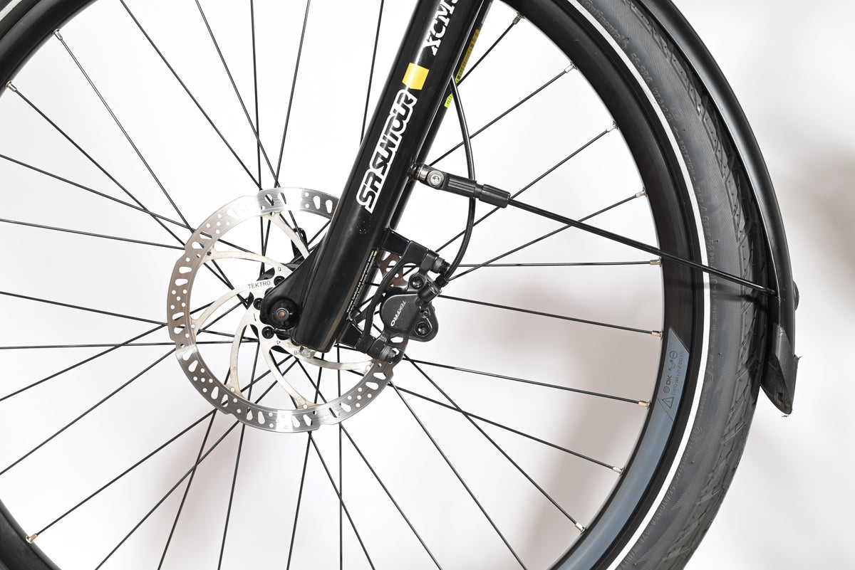 Gros plan sur la roue avant et le frein à disque Tektro du vélo électrique Raymon TourRay E 5.0 chez Loop Sports