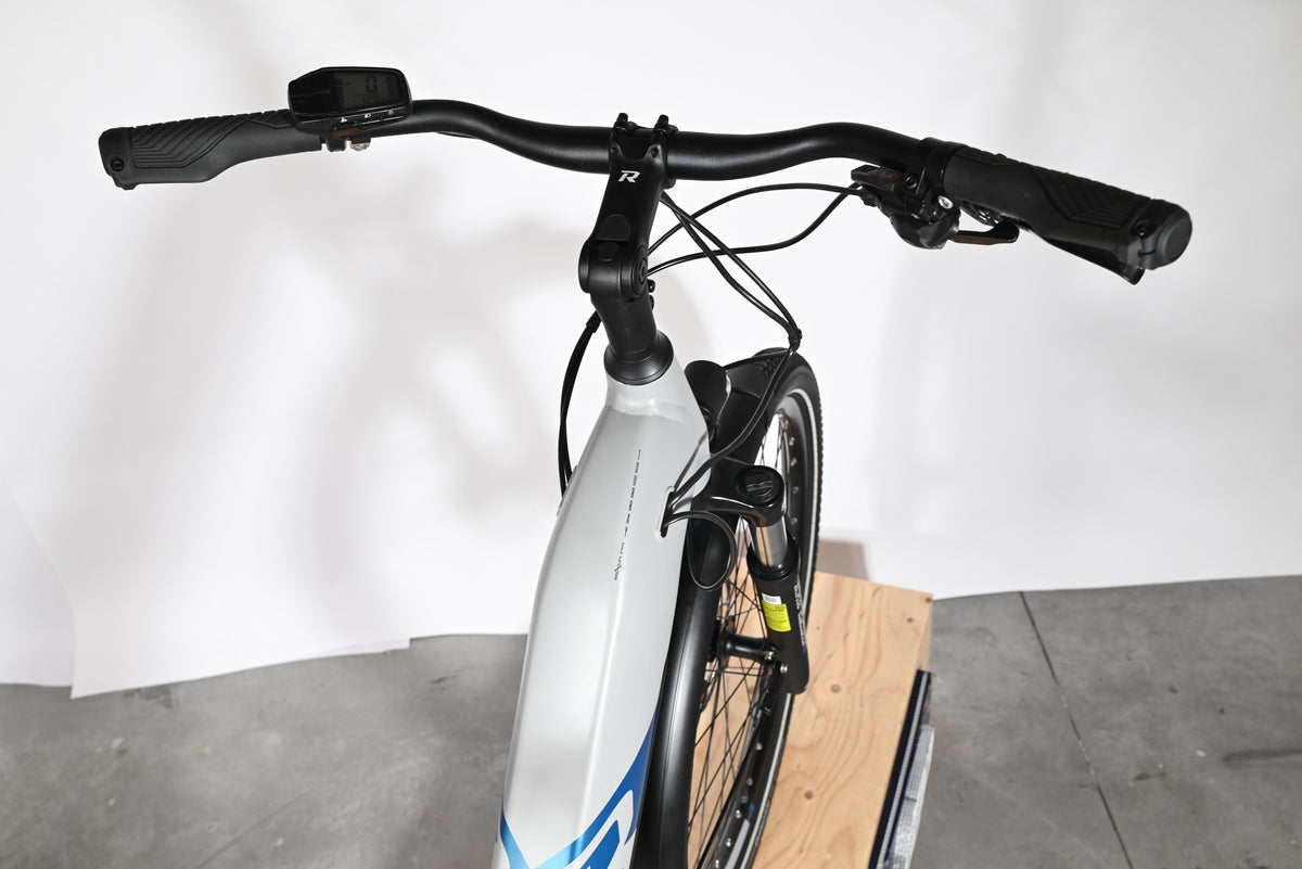 Vue rapprochée du guidon et du cadre gris du vélo électrique Loop Sports Raymon Tourray E 5.0
