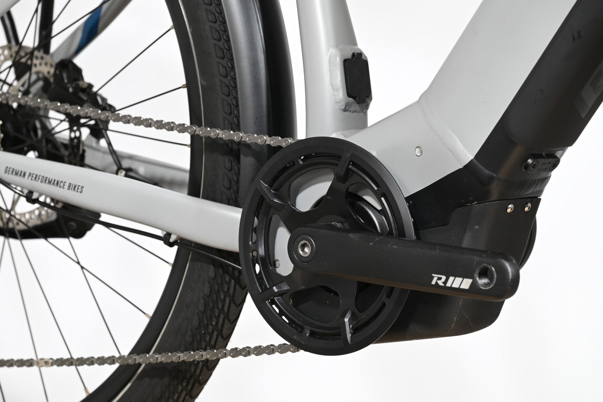 Gros plan sur le pédalier et le moteur électrique d'un vélo Raymon Tourray E 5.0 gris de Loop Sports