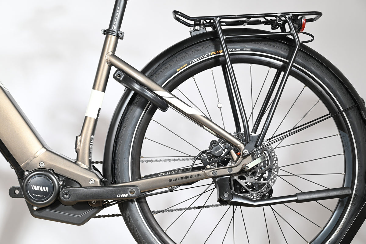 Gros plan sur la roue arrière et le moteur Yamaha du vélo électrique Loop Sports Raymon TourRay E 5.0 gris