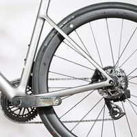 Gros plan sur la transmission et la roue arrière du vélo de route Loop Sports Scott Addict RC Team gris