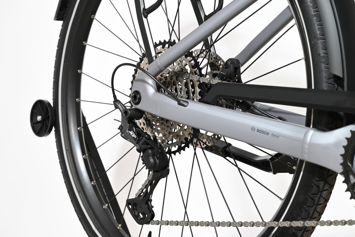Gros plan sur la roue arrière et le dérailleur du vélo électrique Loop Sports Scott Axis 10 gris