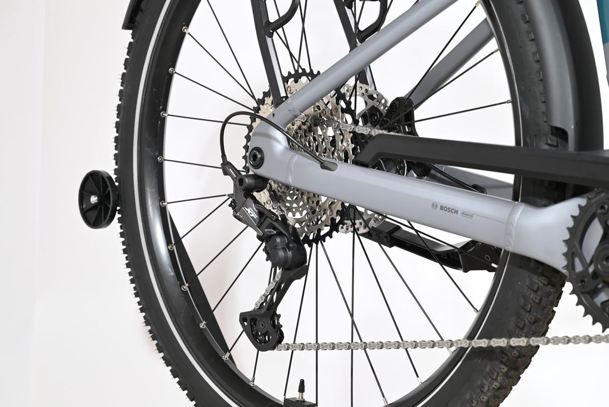 Gros plan sur la roue arrière et le dérailleur Shimano Deore du vélo électrique Loop Sports Scott Axis 10 gris