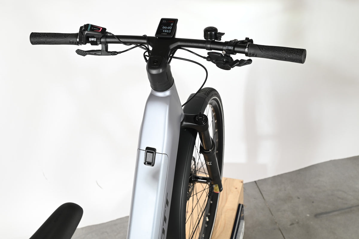 Vue rapprochée du guidon et du cadre argenté du vélo électrique Loop Sports Scott Axis 10 avec écran Bosch intégré