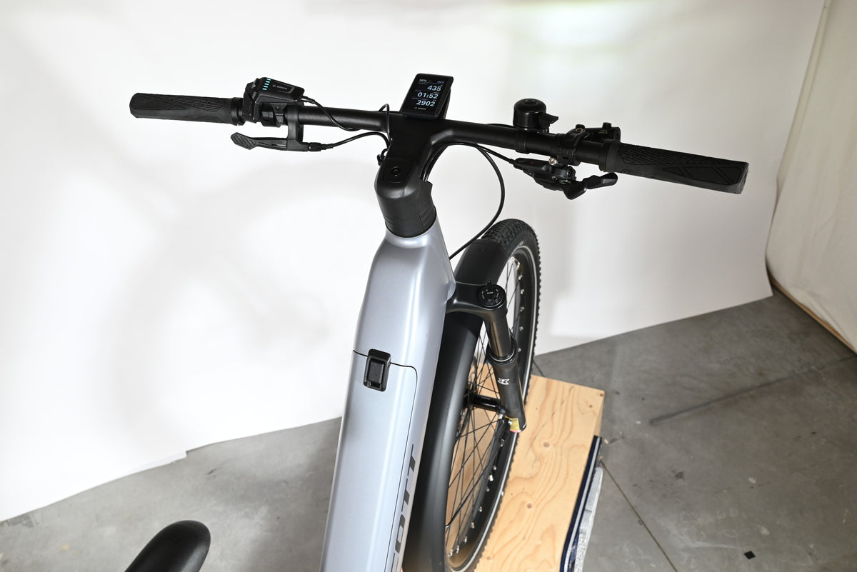 Vue rapprochée du guidon et du cadre gris du vélo électrique Loop Sports Scott Axis 10 avec écran Bosch intégré