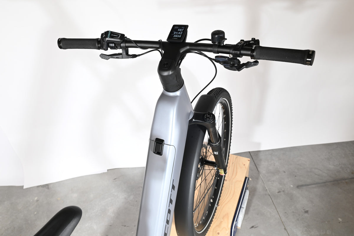 Vue rapprochée du guidon et du cadre gris du vélo électrique Loop Sports Scott Axis 10 avec écran Bosch intégré