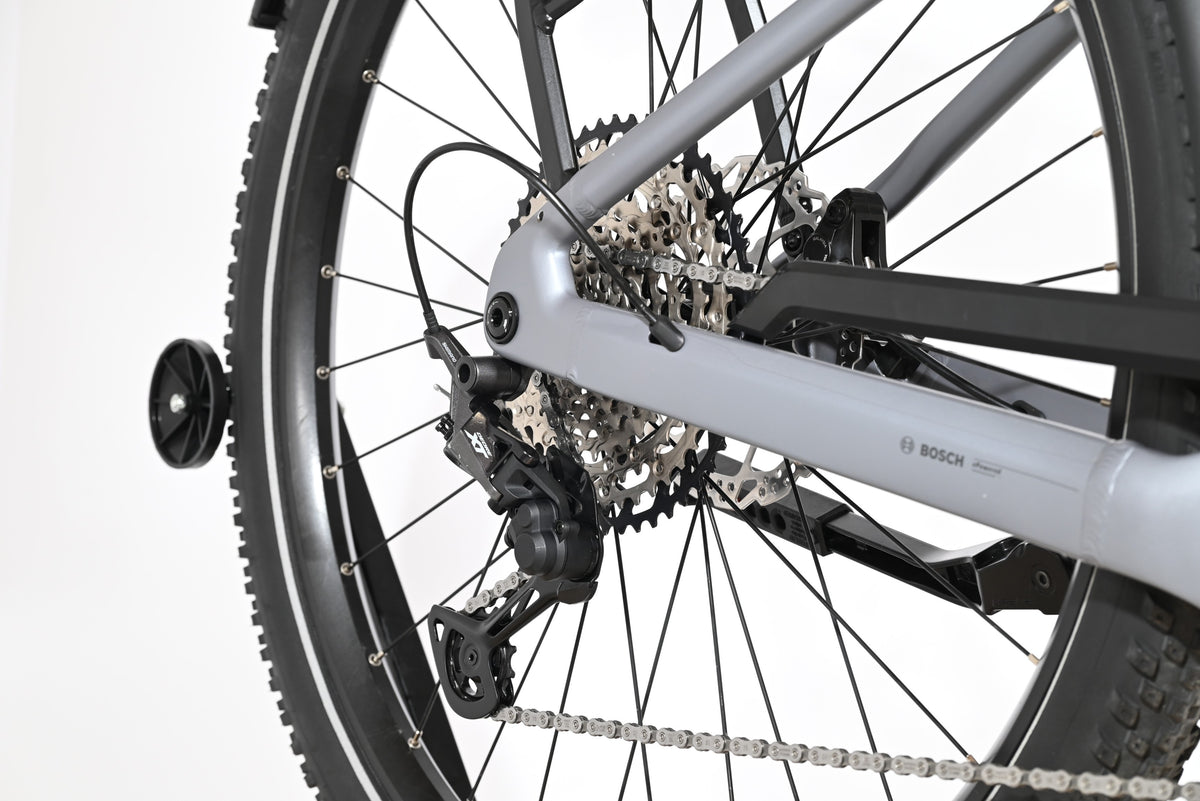 Gros plan sur la roue arrière et le dérailleur Shimano XT du vélo électrique gris Scott Axis 10 de Loop Sports