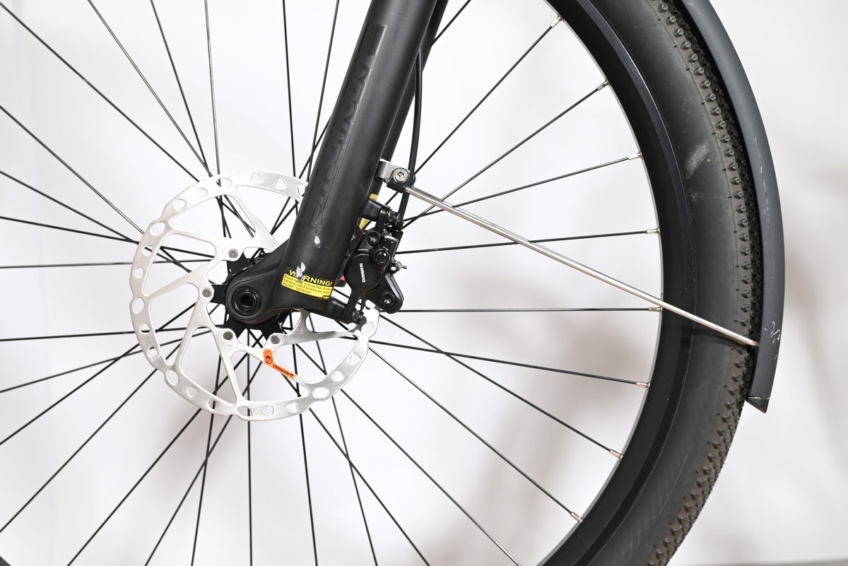 Gros plan sur la roue avant, le frein à disque et la fourche du vélo électrique Loop Sports Scott Axis Eride 10