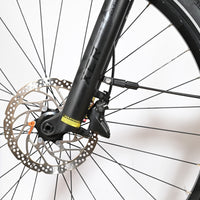 Gros plan sur la roue avant et la fourche à suspension noire du vélo Loop Sports Scott Axis 10 avec frein à disque