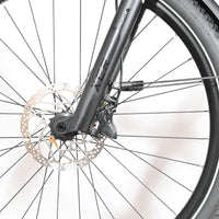 Gros plan sur la roue avant et la fourche suspendue Suntour du vélo électrique Loop Sports Scott Axis 10 noir
