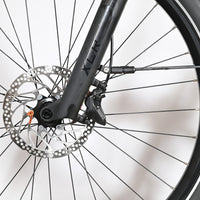 Gros plan sur le frein à disque hydraulique et la fourche avant du vélo Loop Sports Scott Axis 10